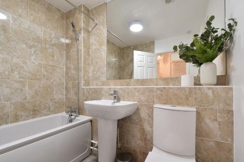 a bathroom with a sink and a toilet and a mirror at Stylish One Bed Apartment Near Cotswolds RAF in Carterton