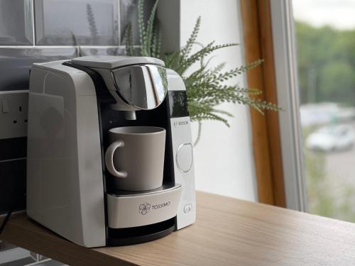 a coffee maker sitting on top of a table at Stylish One Bed Apartment Near Cotswolds RAF in Carterton
