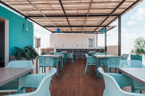 a dining room with blue chairs and tables at The Gallery Condos Playa de Carmen in Playa del Carmen