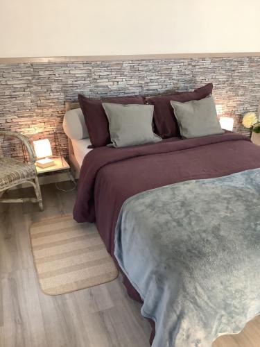 a bedroom with a large bed and a brick wall at La Fagnoul in Ferrières