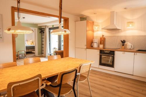 cocina y comedor con mesa de madera y sillas en Hiša Lojz, en Žaga