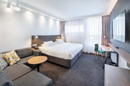 une chambre d'hôtel avec un lit et un canapé dans l'établissement Holiday Inn Prague Airport, an IHG Hotel, à Prague