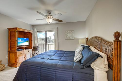 a bedroom with a blue bed and a ceiling fan at Bay Oaks C 2nd Floor in Siesta Key