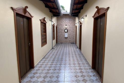 an empty hallway with a tile floor and two doors at Pousada das Orquídeas in Pirenópolis