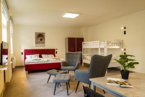 a bedroom with a bed and a table and chairs at Hotel und Hostel Gleisbett in Annaberg-Buchholz