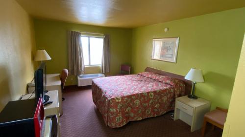 a hotel room with a bed and a television at Sunset Inn-Rolla in Rolla