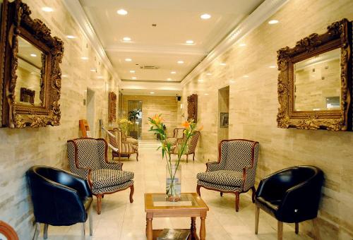 a lobby with chairs and a vase of flowers on a table at Hotel Panamericano in Santiago