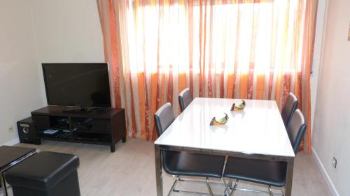 a living room with a table and a television at My Sunny Apartment Barra in Praia da Barra