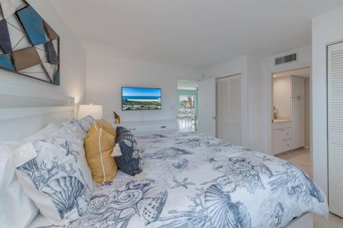 a bedroom with a blue and white bed with pillows at Riverside Club C309 in Marco Island