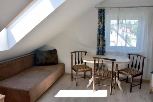 uma sala de estar com um sofá, uma mesa e cadeiras em W Ziołowym Ogrodzie - pokoje z dostępną kuchnią, apartament em Kudowa-Zdrój