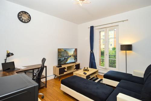 un salon avec un canapé et un bureau dans l'établissement Le Fil Bleu - CENTRE VILLE - ENTIÈREMENT ÉQUIPÉ, à Montluçon