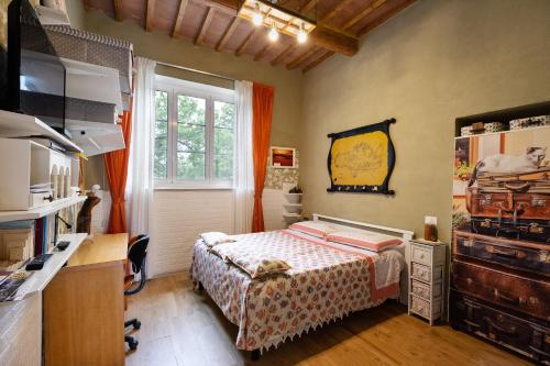 a bedroom with a bed and a desk and a window at La Fabbrichina in Gambassi Terme