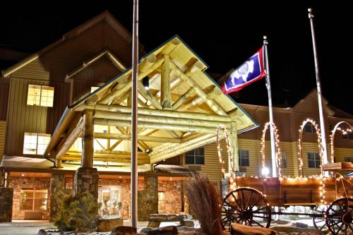 a horse drawn carriage in front of a building with a flag at Arbuckle Lodge Gillette in Gillette