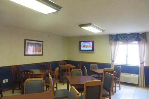 a dining room with tables and chairs and a tv at Baymont by Wyndham Boone in Boone
