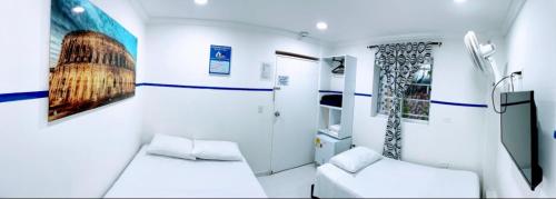 a small room with two beds and a tv at Casa Hotel Manco Mora in Medellín