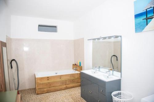 a white bathroom with a tub and a sink at guest mtsangamouji F3 in Mtsamgamouji