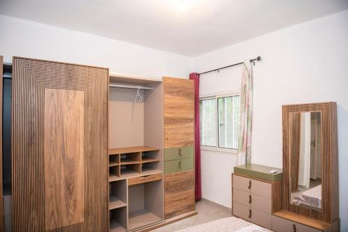 a room with two wooden cabinets and a mirror at guest mtsangamouji F3 in Mtsamgamouji