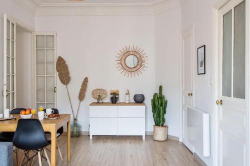 - un salon blanc avec une table et un miroir dans l'établissement Appartement Pertinax - Welkeys, à Nice