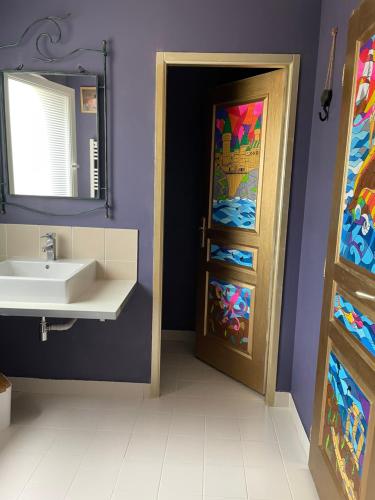 een badkamer met een wastafel, een spiegel en een deur bij Le Maine N 5 - FLÉAC ANGOULEME - Suite Harry Potter in Fléac