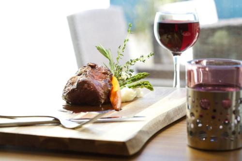 a table with a plate of meat and a glass of wine at Grey Eagle Resort in Calgary