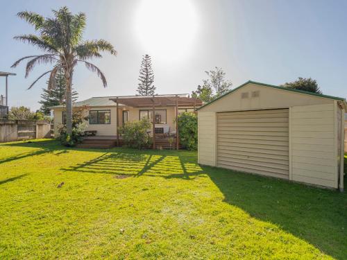 a house with a large yard with a garage at Idyll Thyme - Hahei Holiday Home in Hahei