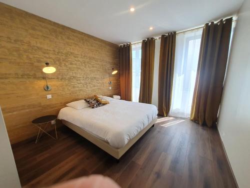 une chambre avec un lit et une grande fenêtre dans l'établissement Legend Majestic - 3 chambres - Parking privé GRATUIT - Centre Ville - Quai de Saône - Gare - fibre, à Mâcon