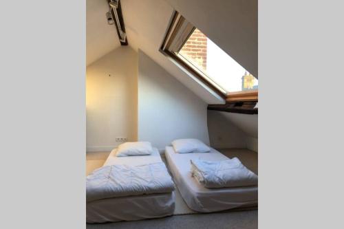 deux lits dans une chambre avec une fenêtre dans l'établissement Charmante Maison Pêcheurs, 141 m2, à Trouville-sur-Mer