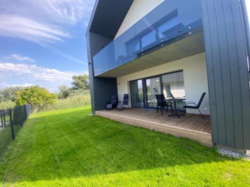 a house with a deck with chairs and a table at KoKo House Palanga in Palanga