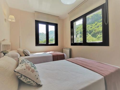 - 2 lits dans une chambre avec 2 fenêtres dans l'établissement Apartamentos La Arandanera, à Tielve