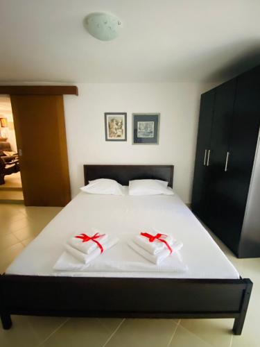 a bed with white sheets and red bows on it at Lake View Apartment Dodosi in Dodoši