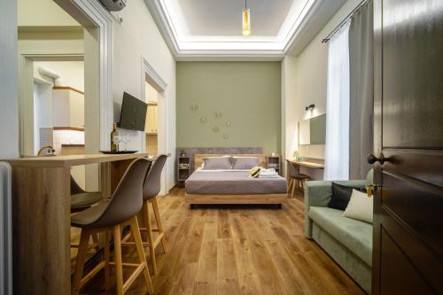 een slaapkamer met een bed, een bureau en een bank bij Karma Athens in Athene