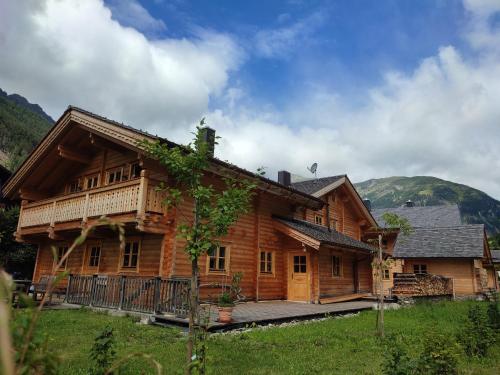 ein Holzhaus mit einer Veranda und einem Berg in der Unterkunft Schlosswirt Chalets & Apartments in Großkirchheim
