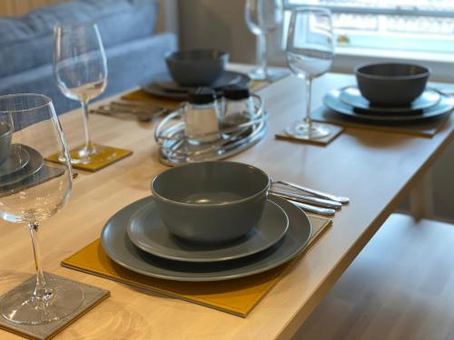 a table with plates and wine glasses on it at Apartment @ Booth Hall in Hereford