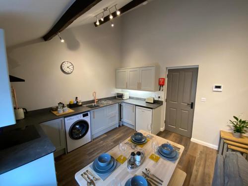 a kitchen with a table in the middle of a room at Apartment @ Booth Hall in Hereford