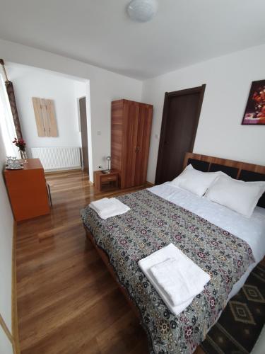 a bedroom with a bed with two towels on it at Pensiunea Agroturistica ANCA&IOANA in Bălceşti