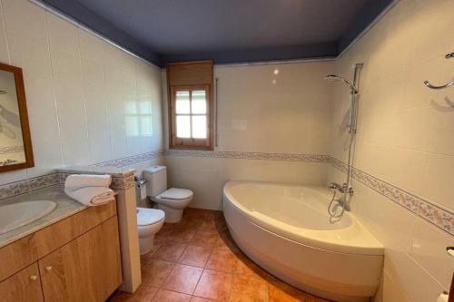 a bathroom with a tub and a toilet and a sink at Ca l’Albert - Casa rural acollidora in Isona