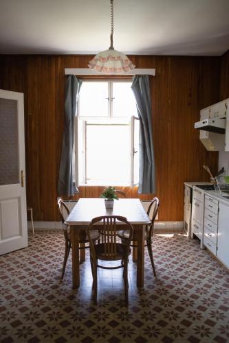 a kitchen with a table and chairs and a window at Mályva-ház Verőce in Verőce