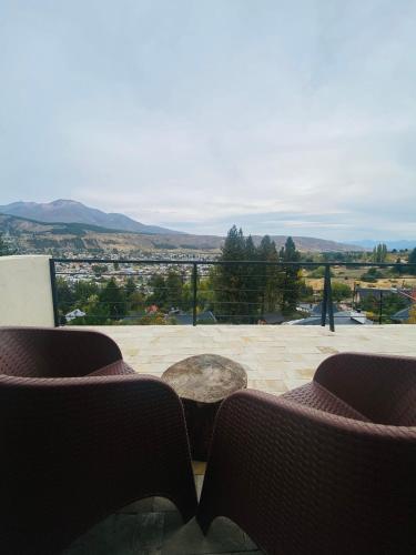 a balcony with chairs and a view of a city at Altos de Esquel in Esquel