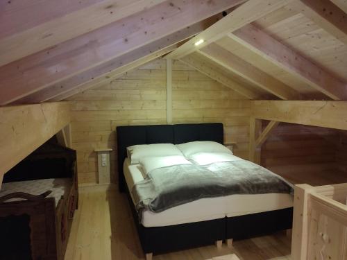 a bedroom with a bed in the attic at Schlosswirt Chalets & Apartments in Großkirchheim