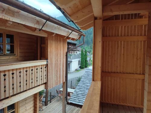 an external view of a wooden house with a balcony at Schlosswirt Chalets & Apartments in Großkirchheim