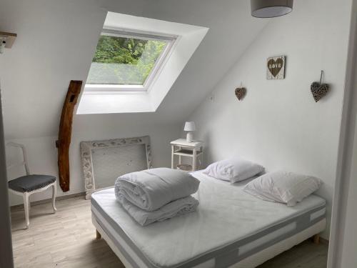 ein weißes Schlafzimmer mit einem Bett und einem Fenster in der Unterkunft Les gîtes du château du cèdre in Manneville-ès-Plains