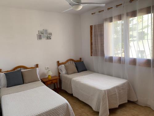 a bedroom with two beds and a window at Llar Soraya - Chalet en Calpe in Calpe