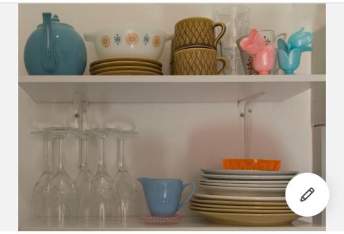 a shelf with dishes and wine glasses and plates at Sundbyvestervarehus in Copenhagen