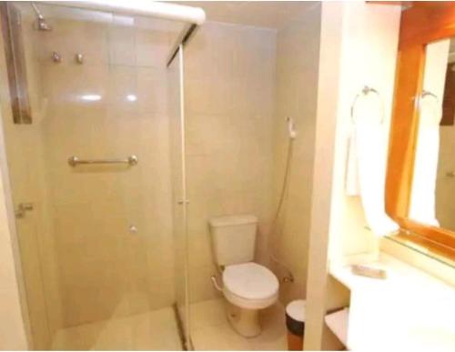 a bathroom with a toilet and a glass shower at Condominio Residencial pousada do Serran0 in Gramado