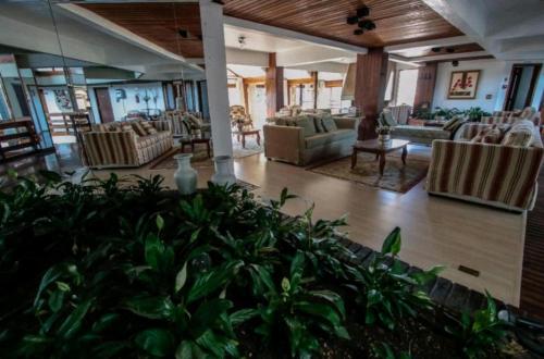 a living room with couches and chairs in a building at Condominio Residencial pousada do Serran0 in Gramado