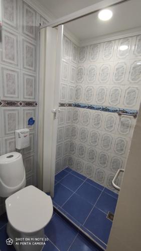a bathroom with a toilet and a shower with blue tiles at Casa Hotel Manco Mora in Medellín