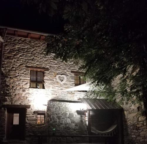 a stone building with lights in front of it at night at La Casetta di Lele e Schina in Arvier