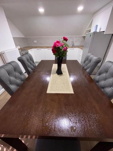 a vase of flowers on a table in a room at Apartman Ambijent in Arandjelovac