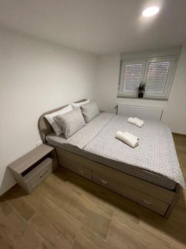 a bedroom with a bed in a room with a window at Apartman Ambijent in Arandjelovac