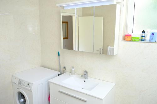 a bathroom with a sink and a washing machine at Urban Apartment Visoko in Visoko